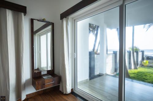 a room with a large window and a mirror at Reunion Ocean Manor - Beach House in Udupi