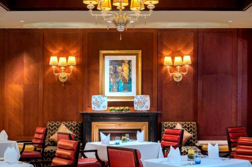 a dining room with tables and chairs and a fireplace at The St. Regis Beijing in Beijing