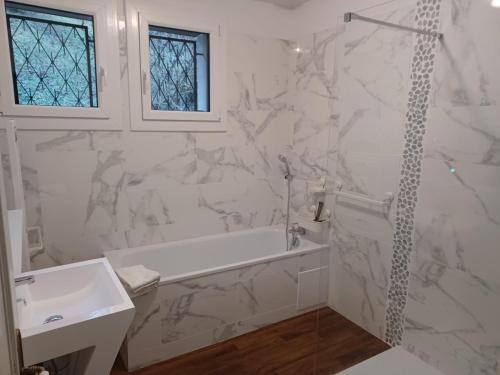 biała łazienka z wanną i umywalką w obiekcie Entre Phare et Moulin w mieście Verzenay