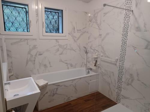 a white bathroom with a tub and a sink at Entre Phare et Moulin in Verzenay