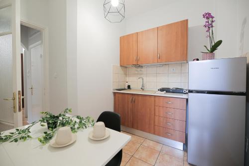 cocina con nevera blanca y mesa blanca en Uranus Apartment, en Tesalónica