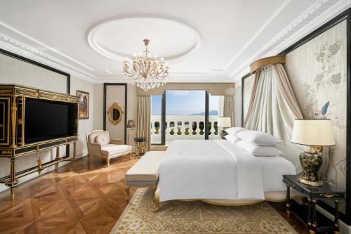 a bedroom with a large white bed and a chandelier at Four Points by Sheraton Lang Son in Lạng Sơn