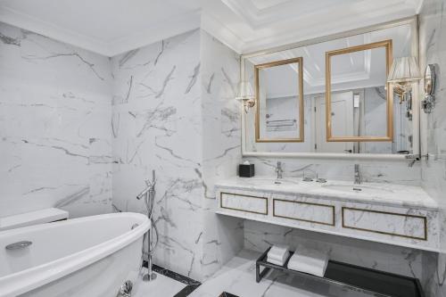 a white bathroom with a tub and a sink at Four Points by Sheraton Lang Son in Lạng Sơn