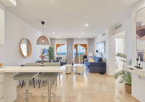 a kitchen and living room with a table and chairs at Marina XI Lovely apartment inside Wyndham Resort in Mijas Costa