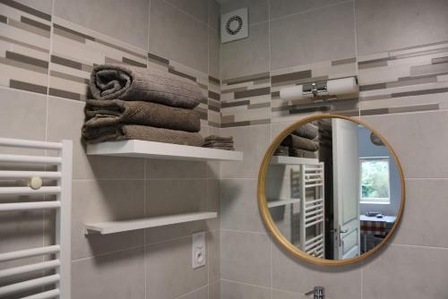 a bathroom with a mirror and towels on a wall at Gîte An Daou Tok in Mellionnec