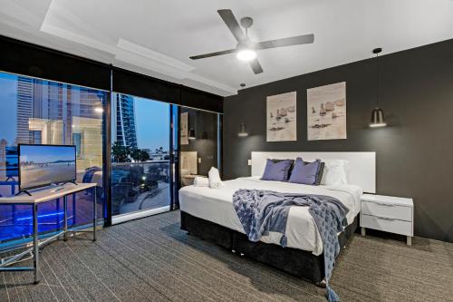 a bedroom with a bed and a desk with a television at Circle on Cavill - Self Contained & Privately Managed - Wow Stay in Gold Coast