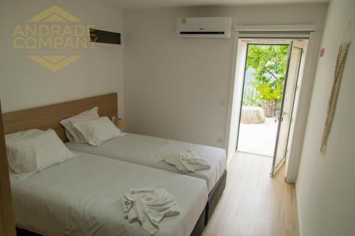 zwei Betten in einem Hotelzimmer mit Handtüchern darauf in der Unterkunft Refúgio da Suite 6 in Pinhão
