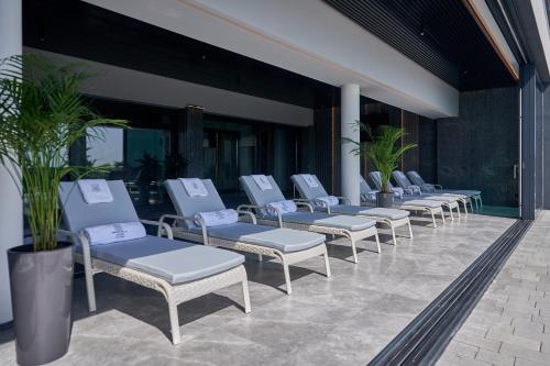a row of chaise lounge chairs on a patio at WHITE HILLS HOTEL spa&sport in Uzhhorod