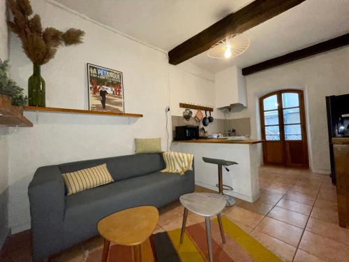 uma sala de estar com um sofá e uma mesa em Cocon au cœur du centre-ville d'Arles em Arles