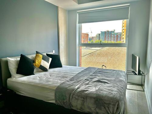 Un dormitorio con una cama grande y una ventana en Captivating 2-Bed Skyview Apartment in Leeds, en Leeds