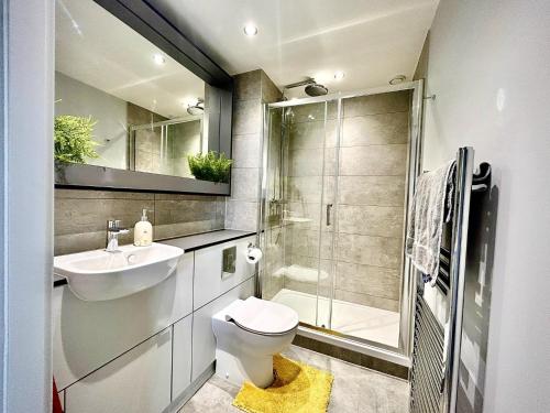 een badkamer met een toilet, een wastafel en een douche bij Captivating 2-Bed Skyview Apartment in Leeds in Leeds