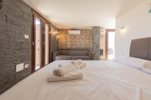 a bedroom with a large white bed with towels on it at Appartamenti vista Mare in Porto Cesareo