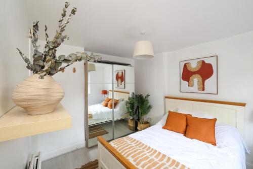 - une chambre avec un lit et un vase de fleurs dans l'établissement W London apt for 4. Open plan kitchen/living room, à Londres