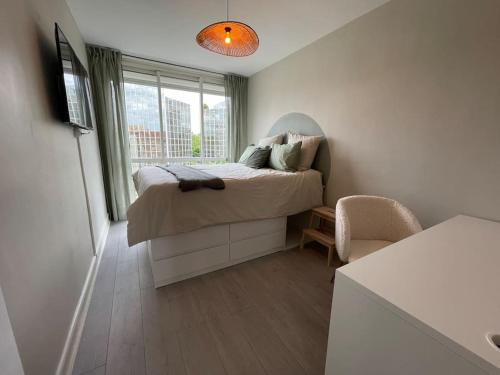 niewielka sypialnia z łóżkiem i oknem w obiekcie Le Compans: exceptionnel T5 en berges du Canal w Tuluzie
