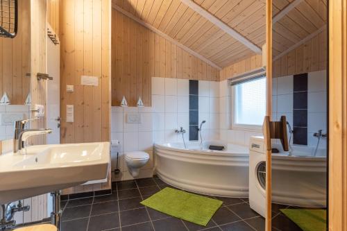 een badkamer met een bad, een toilet en een wastafel bij Nordseenest am Deich in Wesselburenerkoog