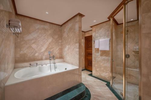 La salle de bains est pourvue d'une baignoire et d'une douche. dans l'établissement Le Meridien Jakarta, à Jakarta
