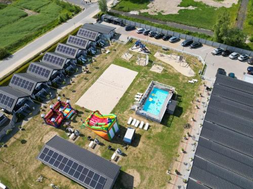 uma vista superior de um edifício com painéis solares e uma piscina em Holiday-Camp em Rusinowo