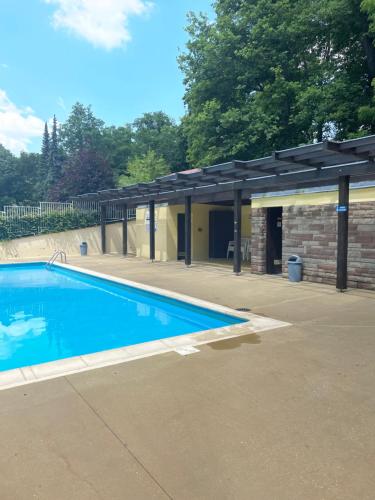 - une piscine avec un pavillon à côté d'un bâtiment dans l'établissement Charmant studio en pleine nature, à Klingenthal