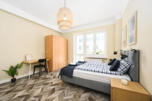 a bedroom with a bed and a desk at Apartament 109 w centrum Gdyni ProstyWynajem in Gdynia