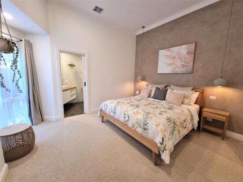a bedroom with a bed and a table and a window at Live - Play - Stay - East Geelong in Geelong