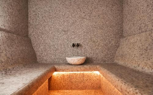 a bathroom with a tub with a bowl on it at WHITE HILLS HOTEL spa&sport in Uzhhorod