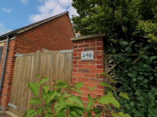 a brick house with a wooden gate and a fence at Modern Room with Private Outdoor space Pass The Keys in Gosforth