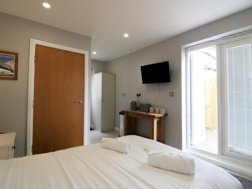 Un pat sau paturi într-o cameră la Modern Room with Private Outdoor space Pass The Keys