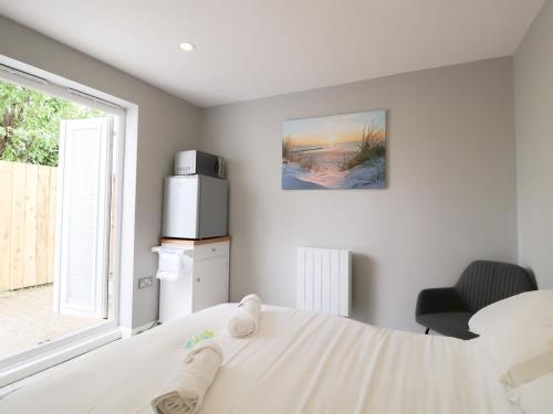 a bedroom with a white bed and a window at Modern Room with Private Outdoor space Pass The Keys in Gosforth
