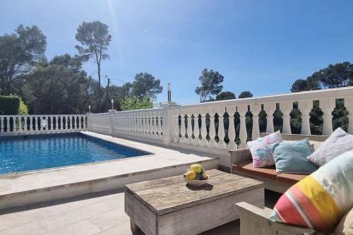 eine Terrasse mit einer Bank und einem Pool in der Unterkunft Casa Alexandra in Alboy