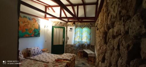 a room with a bed and a stone wall at La Actoru` in Vama Veche