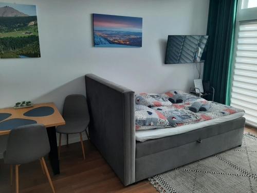 弗次瓦夫的住宿－Aparta Lotnisko，卧室配有1张床、1张桌子和1张桌子以及椅子。