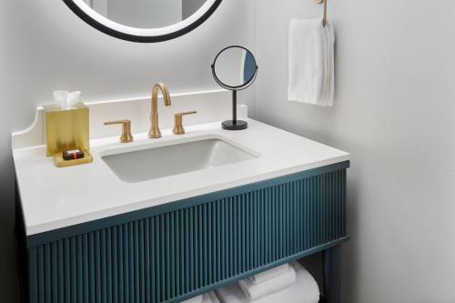 a bathroom with a sink and a mirror at The Tremont House, Galveston, a Tribute Portfolio Hotel in Galveston