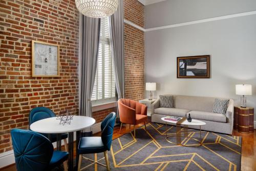 a living room with a couch and tables and chairs at The Tremont House, Galveston, a Tribute Portfolio Hotel in Galveston