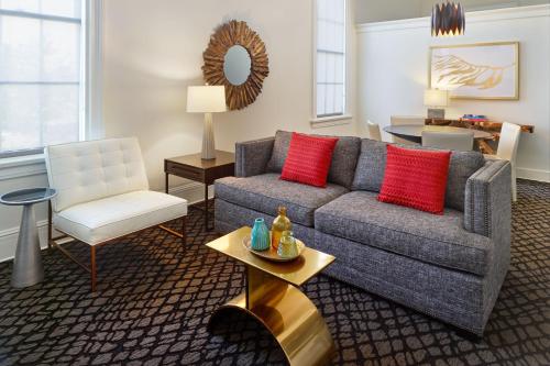 a living room with a couch and a chair at The Tremont House, Galveston, a Tribute Portfolio Hotel in Galveston