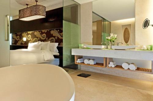 a bedroom with a bed and a bathroom with a sink at The Westin Gurgaon, New Delhi in Gurgaon