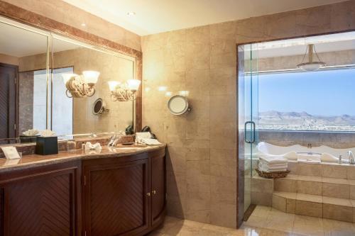 uma casa de banho com um lavatório e um chuveiro em Sheraton Chihuahua Soberano em Chihuahua