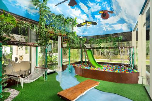 a play room with a slide and a playground at Mustika Yogyakarta Resort and Spa in Yogyakarta