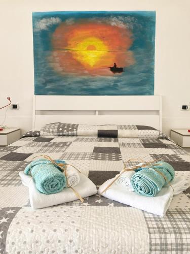 a bedroom with two beds with pillows and a painting at La Meriggia B&B in Pisciotta