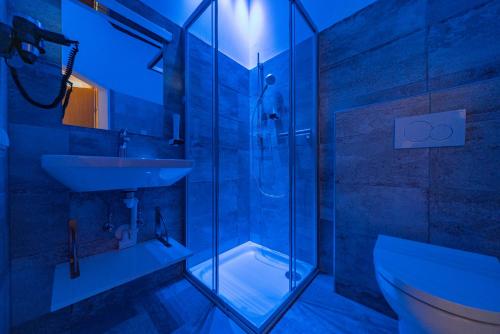 uma casa de banho com uma cabina de duche em vidro e um lavatório. em Haus Weyregg - Pension em Weyregg