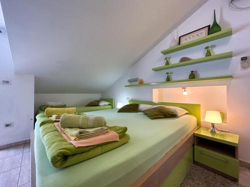 a bedroom with two beds with green sheets at Palma Apartments in Kotor