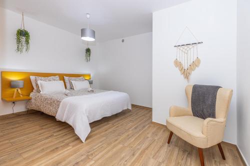 a bedroom with a bed and a chair at Ilha Natura in Santana