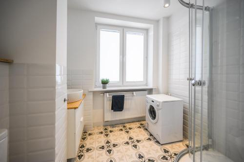 a bathroom with a shower and a washing machine at Apartament 110 w centrum Gdyni ProstyWynajem in Gdynia