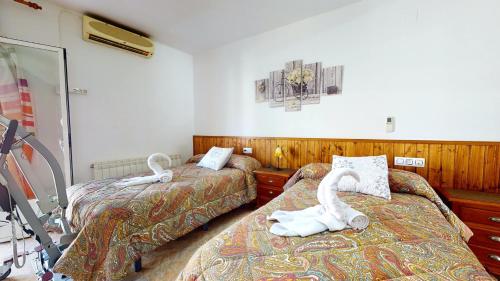 - une chambre d'hôtel avec 2 lits avec des cygnes dans l'établissement CazorSierra, bonita vivienda en Cazorla, à Cazorla