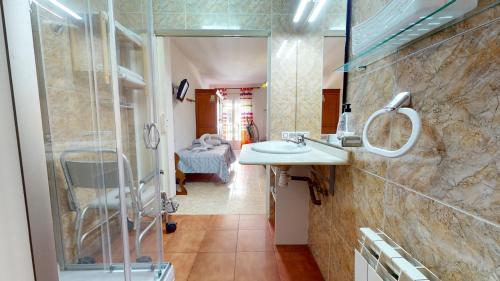 La salle de bains est pourvue d'un lavabo et d'une douche. dans l'établissement CazorSierra, bonita vivienda en Cazorla, à Cazorla