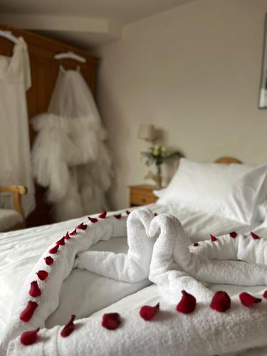 a bed with two white towels with hearts on it at Sporthotel Victoria in Gstaad