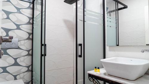 ein Bad mit einem Waschbecken und einer Dusche in der Unterkunft Kardinia Hotel in Mezitli