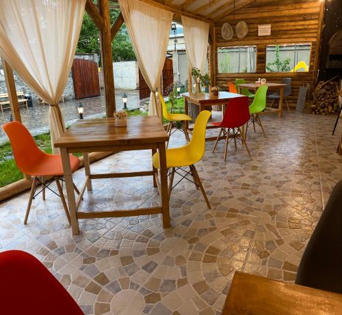ein Esszimmer mit Tischen und bunten Stühlen in der Unterkunft NOY Guest House B&B in Wanadsor