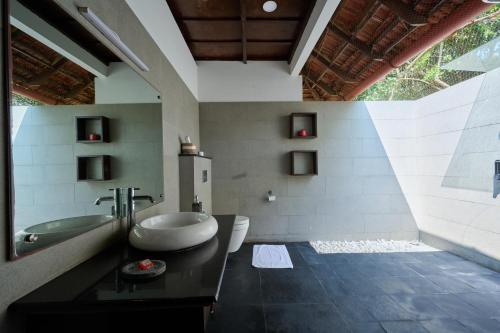 Un baño con bañera, inodoro y lavabo. en Seclude Kerala, Marari Sands, en Mararikulam