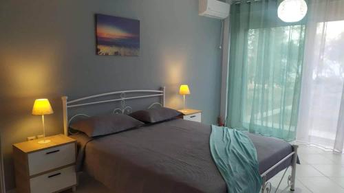 una camera da letto con un letto con due lampade e una finestra di Blue Ocean Aidipsos a Edipsos