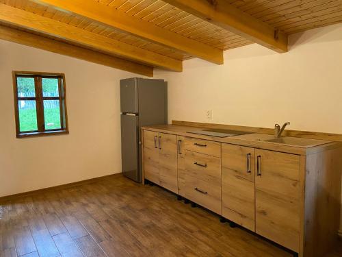 una cocina con nevera de acero inoxidable y armarios de madera en Casuta Bunicilor Corbii de Piatra, en Corbi